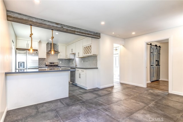 kitchen with hanging light fixtures, tasteful backsplash, white cabinetry, appliances with stainless steel finishes, and a barn door