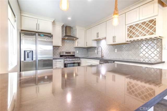 kitchen featuring tasteful backsplash, sink, wall chimney exhaust hood, appliances with stainless steel finishes, and decorative light fixtures