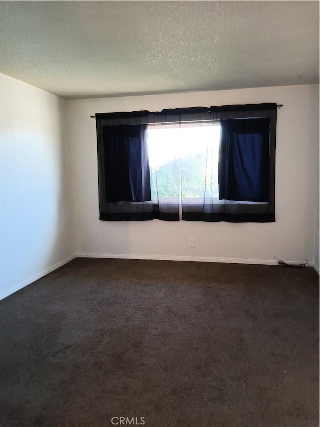 carpeted spare room featuring a textured ceiling