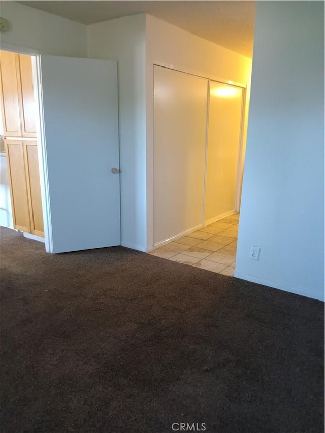 unfurnished bedroom with a closet and light carpet