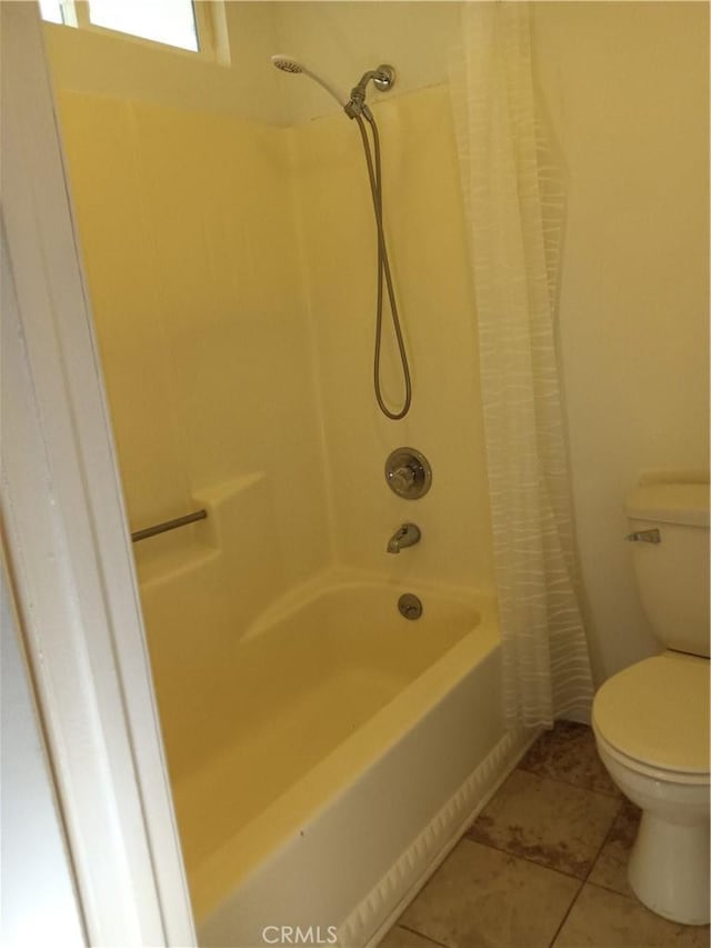 bathroom with toilet, shower / tub combo, and tile patterned floors