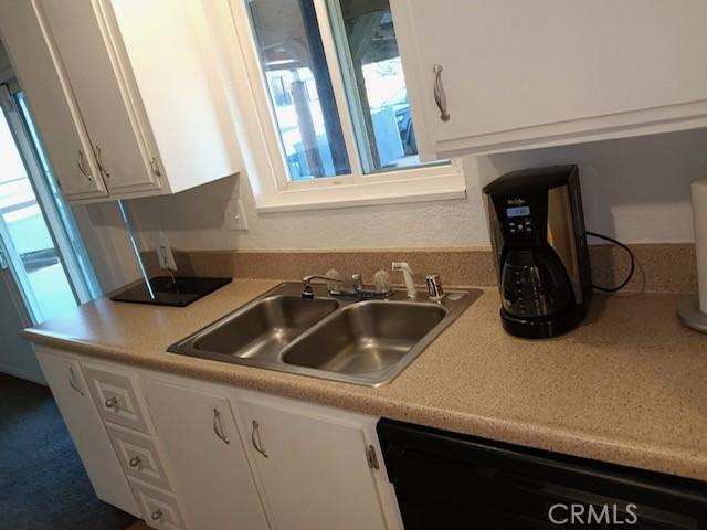 kitchen with sink, white cabinets, and dishwasher