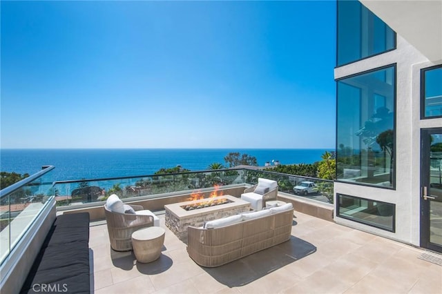 balcony with a water view and an outdoor fire pit