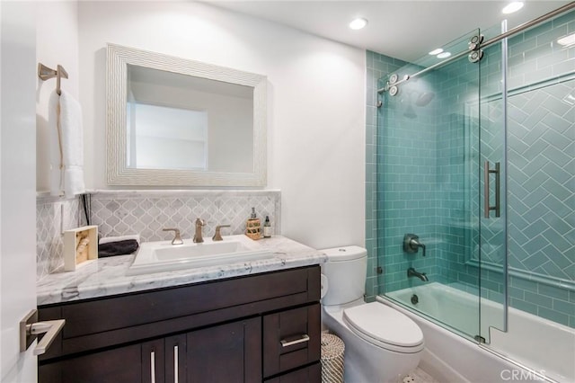 full bathroom with vanity, toilet, decorative backsplash, and bath / shower combo with glass door