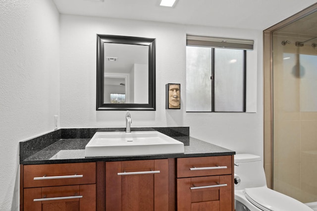 bathroom with vanity, a shower, and toilet