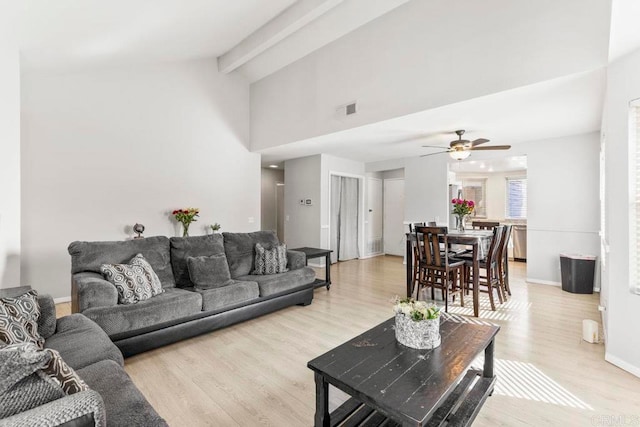 living room featuring ceiling fan, vaulted ceiling with beams, and light wood-type flooring