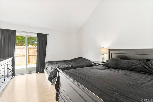 bedroom with access to outside, lofted ceiling, and light hardwood / wood-style floors