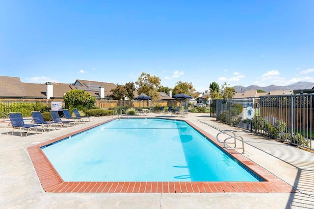 view of swimming pool with a patio and a mountain view