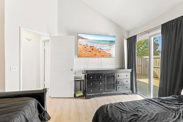 bedroom with light hardwood / wood-style floors, lofted ceiling, and access to exterior