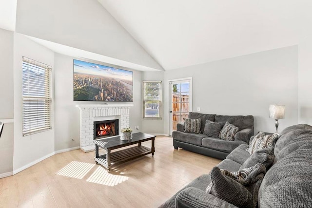 living room featuring light hardwood / wood-style flooring, a fireplace, high vaulted ceiling, and a wealth of natural light