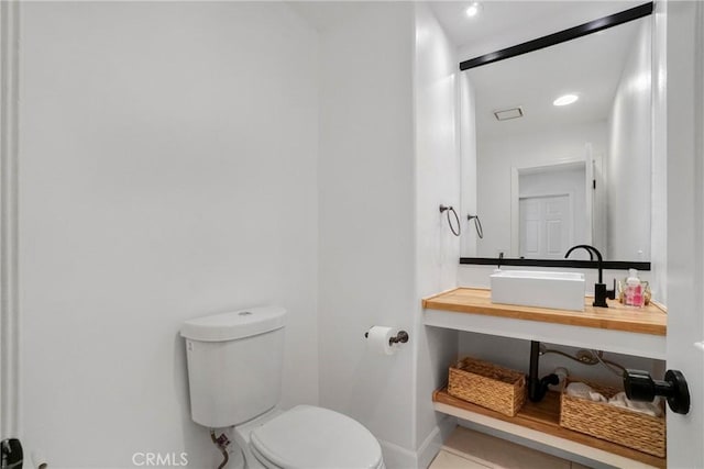 bathroom featuring tile patterned flooring, vanity, and toilet