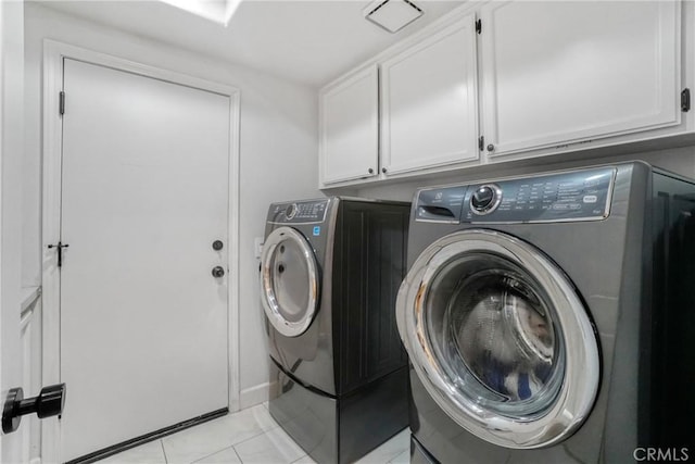 laundry room with light tile patterned flooring, cabinets, and independent washer and dryer