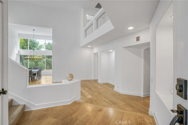 hallway featuring hardwood / wood-style floors and a notable chandelier