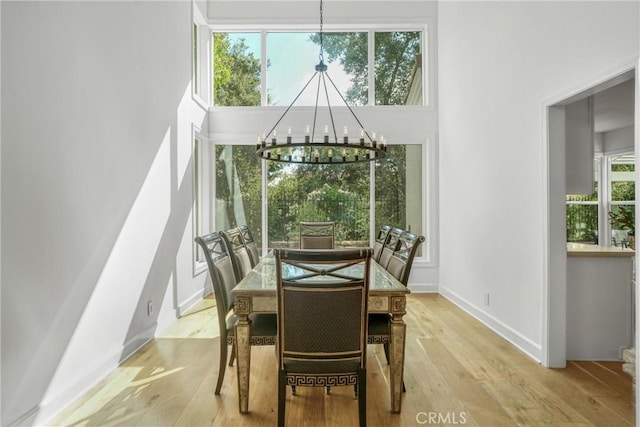 dining space with light wood-type flooring and an inviting chandelier