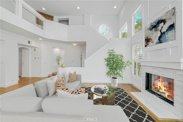 living room featuring light hardwood / wood-style flooring and a towering ceiling