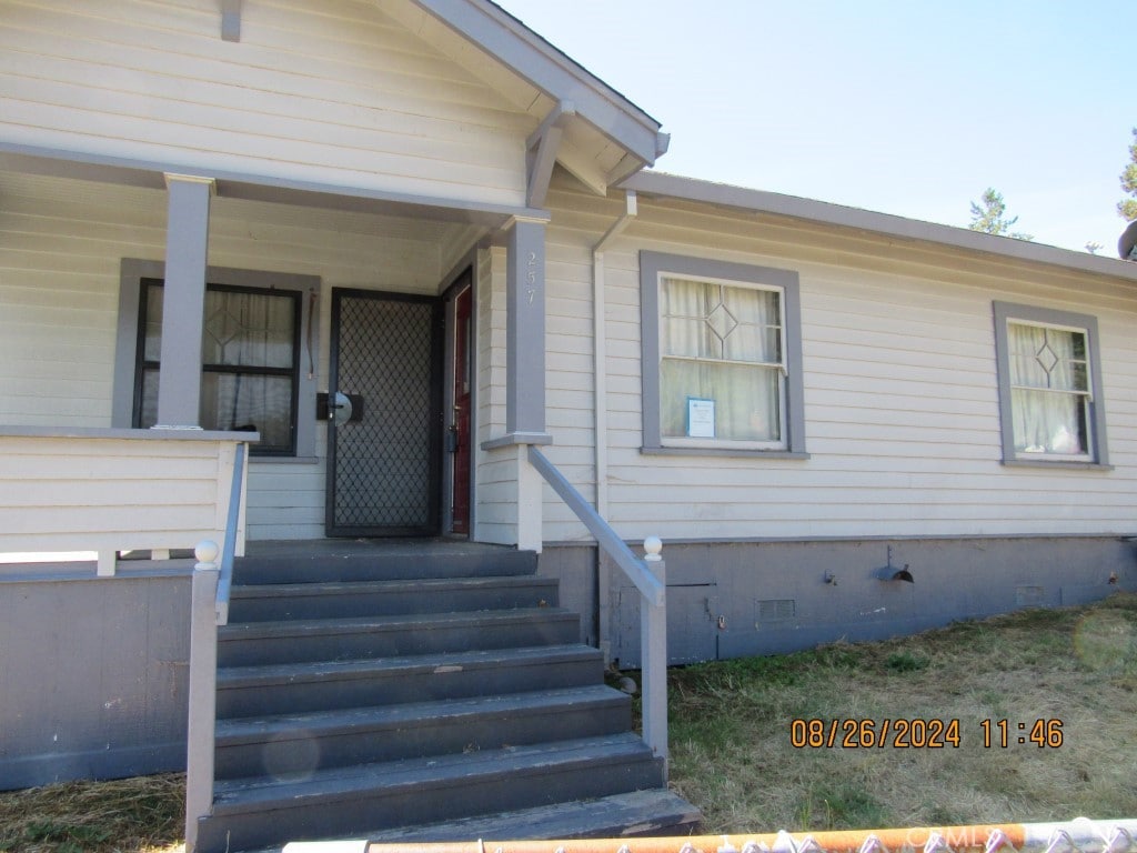 view of exterior entry featuring covered porch