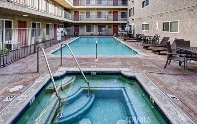 view of swimming pool with a hot tub