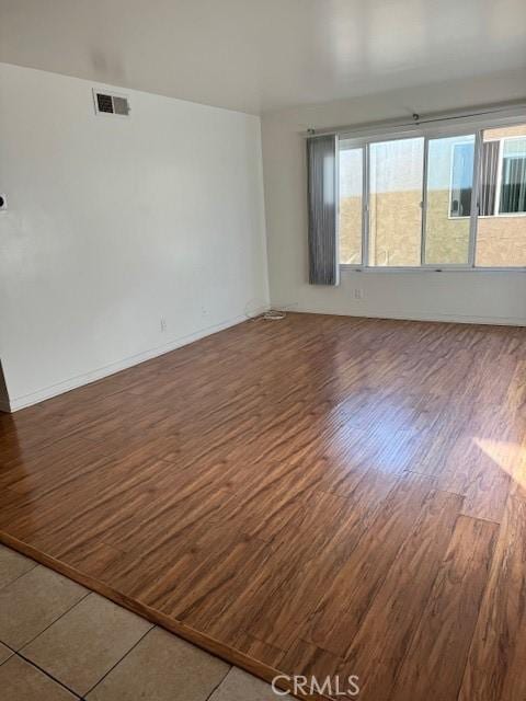 empty room with a healthy amount of sunlight and dark hardwood / wood-style floors