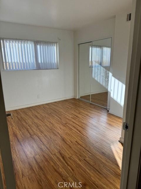 empty room with hardwood / wood-style flooring and a healthy amount of sunlight