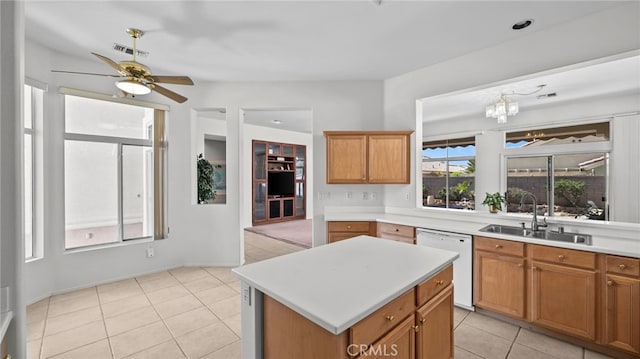 kitchen featuring ceiling fan with notable chandelier, sink, dishwasher, a kitchen island, and light tile patterned flooring