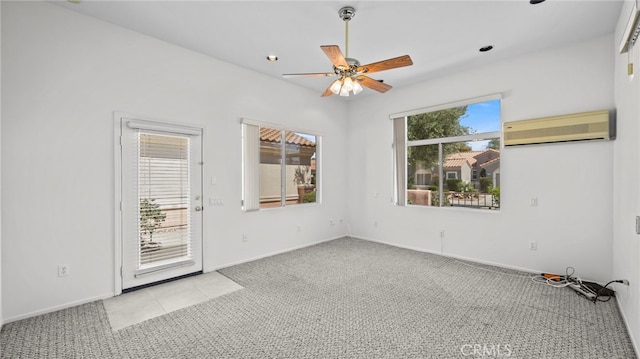 spare room featuring ceiling fan, light colored carpet, and a wall unit AC