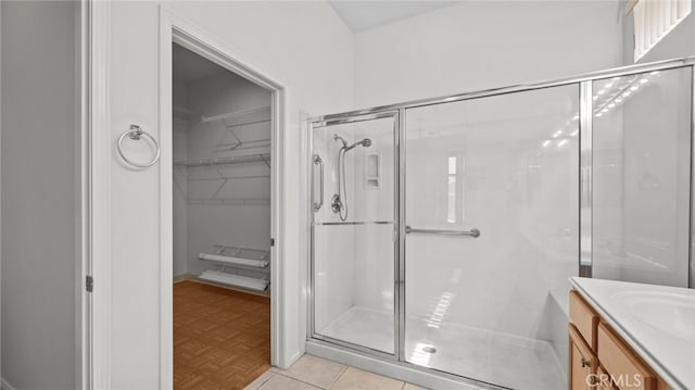 bathroom featuring vanity, a shower with door, and parquet floors