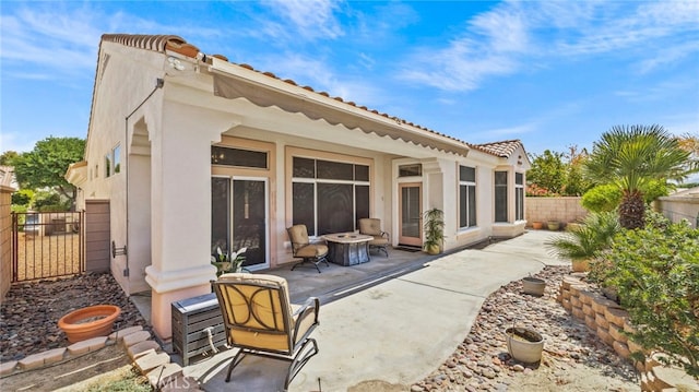 back of property featuring a patio and an outdoor fire pit