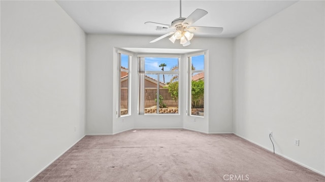 carpeted spare room featuring ceiling fan