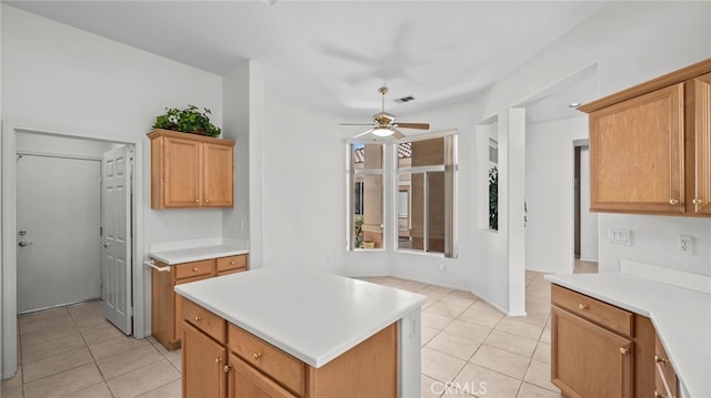 kitchen with ceiling fan, a center island, and light tile patterned floors