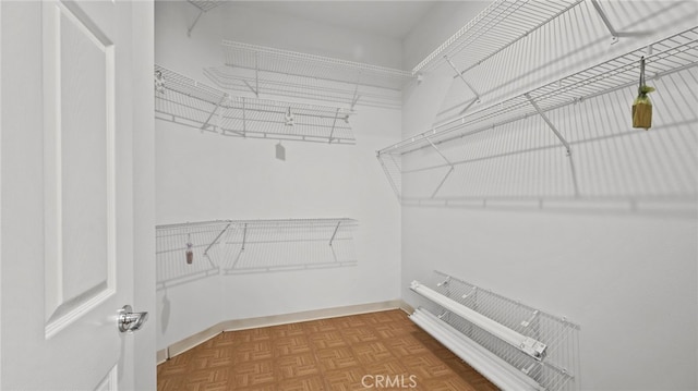 spacious closet featuring parquet flooring