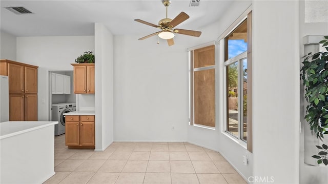 interior space featuring ceiling fan, light tile patterned floors, white fridge, and washer / dryer