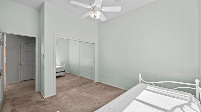 bedroom featuring ceiling fan, a closet, and light carpet