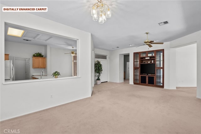 unfurnished living room with light colored carpet and ceiling fan with notable chandelier