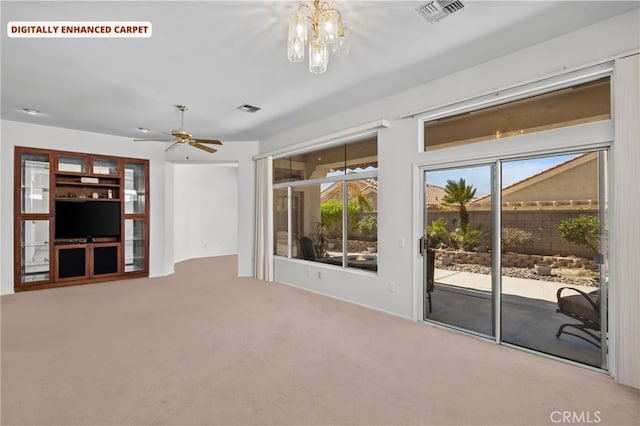 unfurnished living room featuring carpet flooring and ceiling fan with notable chandelier