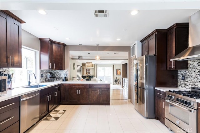 kitchen featuring plenty of natural light, sink, stainless steel appliances, and decorative light fixtures