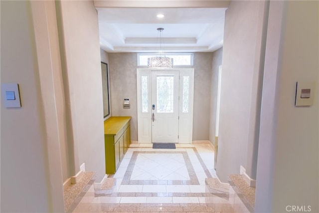 foyer entrance featuring a chandelier and a tray ceiling