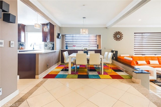 dining space with beamed ceiling, light tile patterned floors, ornamental molding, and sink