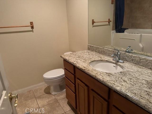 bathroom with baseboards, vanity, toilet, and tile patterned floors