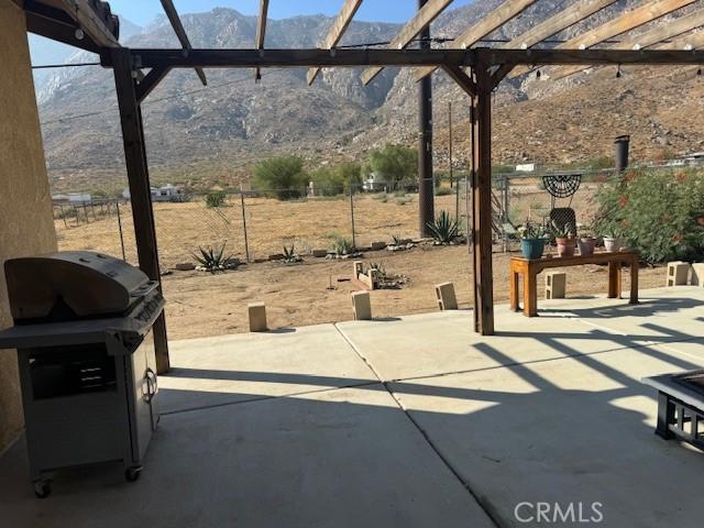 view of patio / terrace with fence, a mountain view, and a pergola