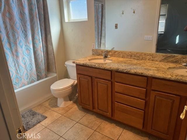 full bathroom featuring double vanity, tile patterned flooring, a sink, and toilet