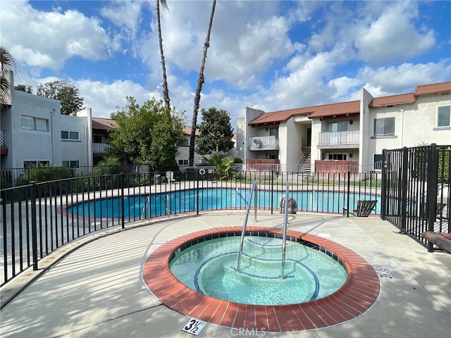 view of swimming pool with a hot tub