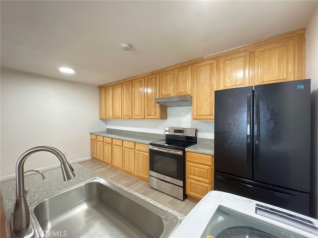 kitchen with stainless steel range with electric stovetop, black refrigerator, light hardwood / wood-style floors, and sink