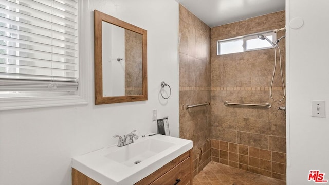 bathroom featuring vanity, a tile shower, and tile patterned floors