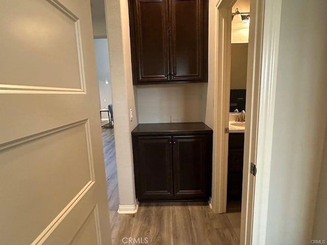 hall with light hardwood / wood-style floors and sink