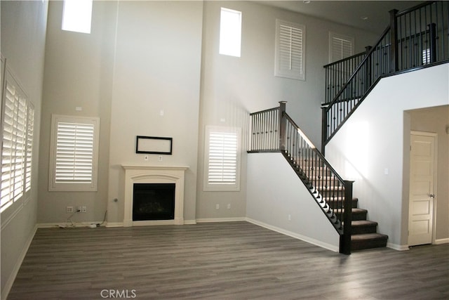 unfurnished living room with a high ceiling and dark hardwood / wood-style floors