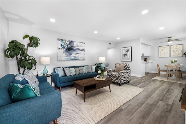 living room with wood-type flooring and ceiling fan