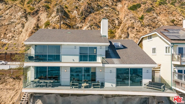 rear view of property featuring a patio area and a balcony