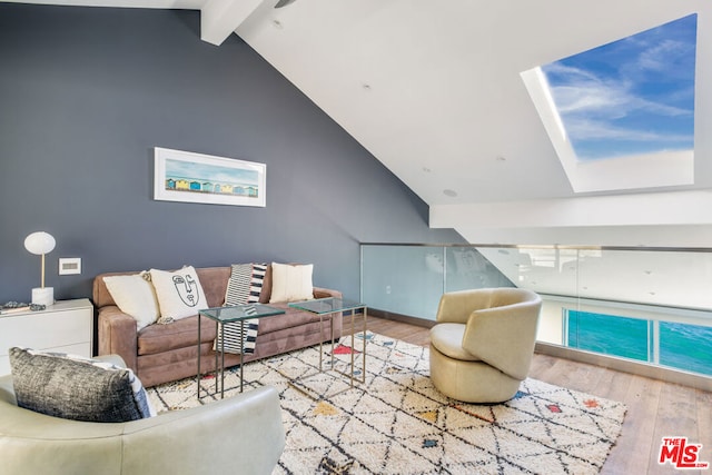 living room featuring lofted ceiling with beams and light hardwood / wood-style floors