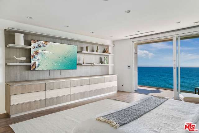 bedroom featuring access to exterior, a water view, and dark hardwood / wood-style floors