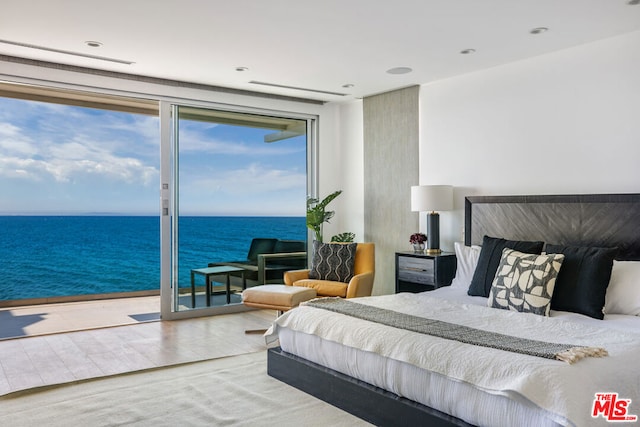 bedroom featuring access to exterior, a water view, and wood-type flooring